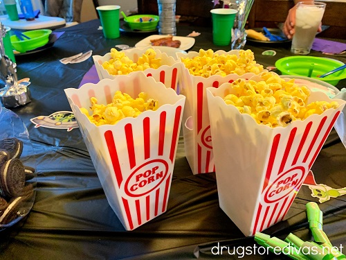 Four plastic popcorn boxes filled with popcorn.