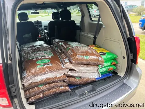 Bags of mulch and Miracle Gro in the back of a mini van.
