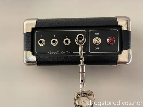 Am amplifier key holder on a wall with some keys in it.