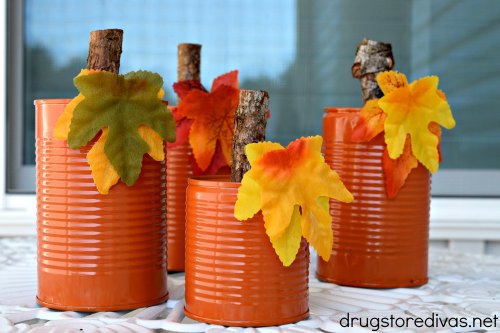 Four tin can pumpkins on a table.