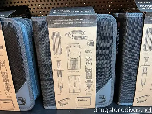 Three guitar maintenance kits on a shelf.