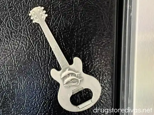 A guitar-shaped bottle opener on a fridge.
