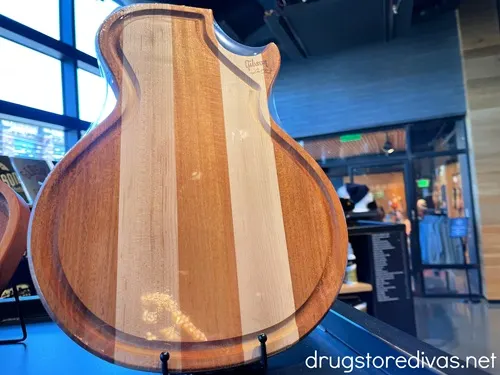 A guitar shaped cutting board on display in a store.