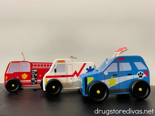 A wooden firetruck, ambulance, and police car made by Melissa and Doug.
