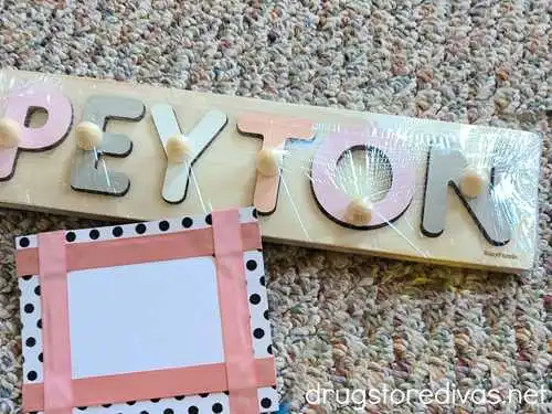 A wooden name puzzle of the name PEYTON with a notecard next to it.