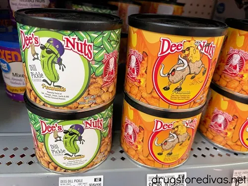 Six containers of Dee's Nuts on a shelf.