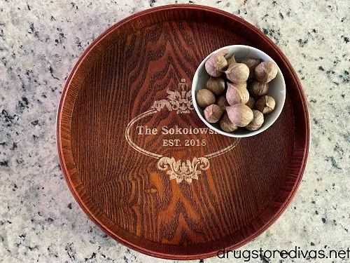 Engraved tray with a bowl of nuts on it.