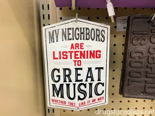 A metal sign that says "My Neighbors Are Listening To Great Music Whether They Like It Or Not".