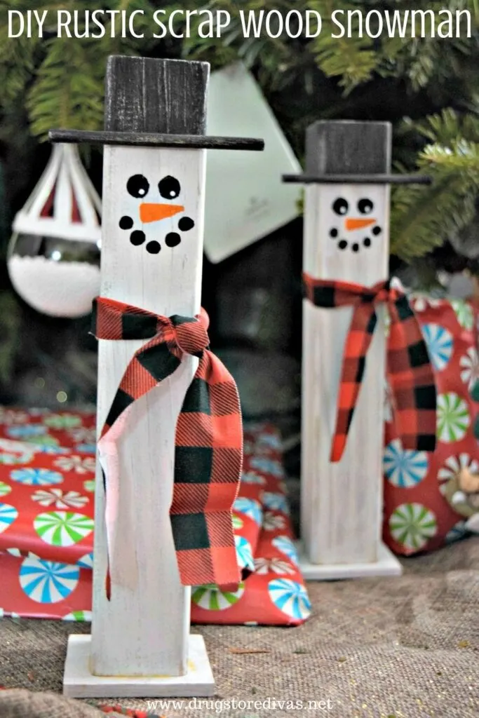 Scrap wood painted to look like a snowman, under a Christmas tree, with the words "DIY Rustic Scrap Wood Snowman" digitally written on top.