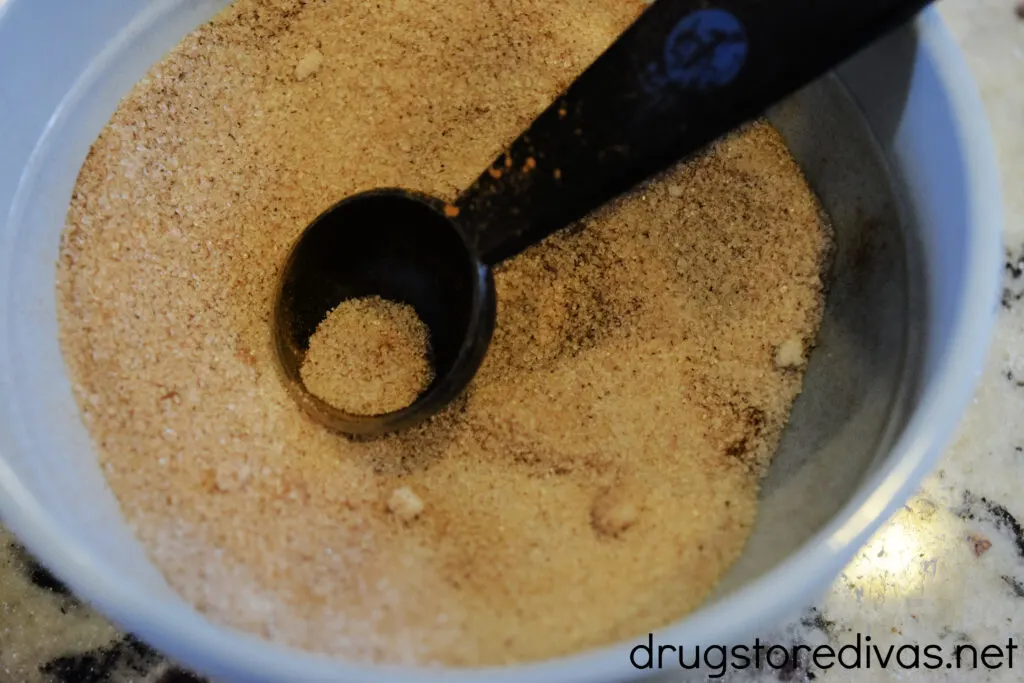 Cinnamon and sugar in a bowl with a measuring spoon in it.