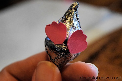 Pink feet on the bottom of two silver Hershey's Kisses.
