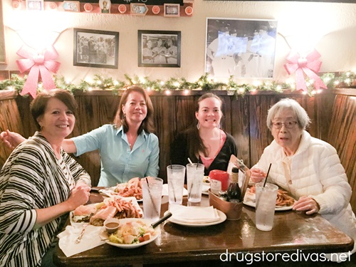 Four women at a wooden booth with food in front of them at a restaurant (The Copper Penny in Wilmington, North Carolina).