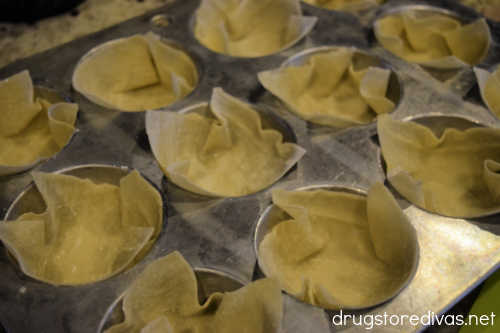 Wonton wrappers in a muffin tin.