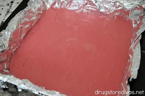Pink fudge in a foil-lined pan.