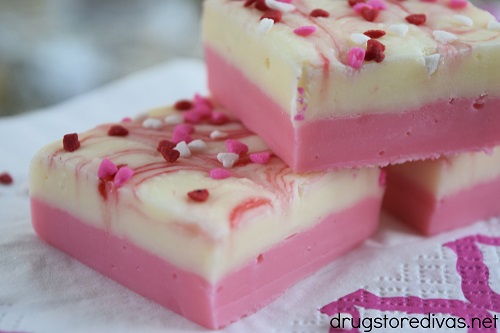 Three pieces of pink and white Valentine's Day fudge.