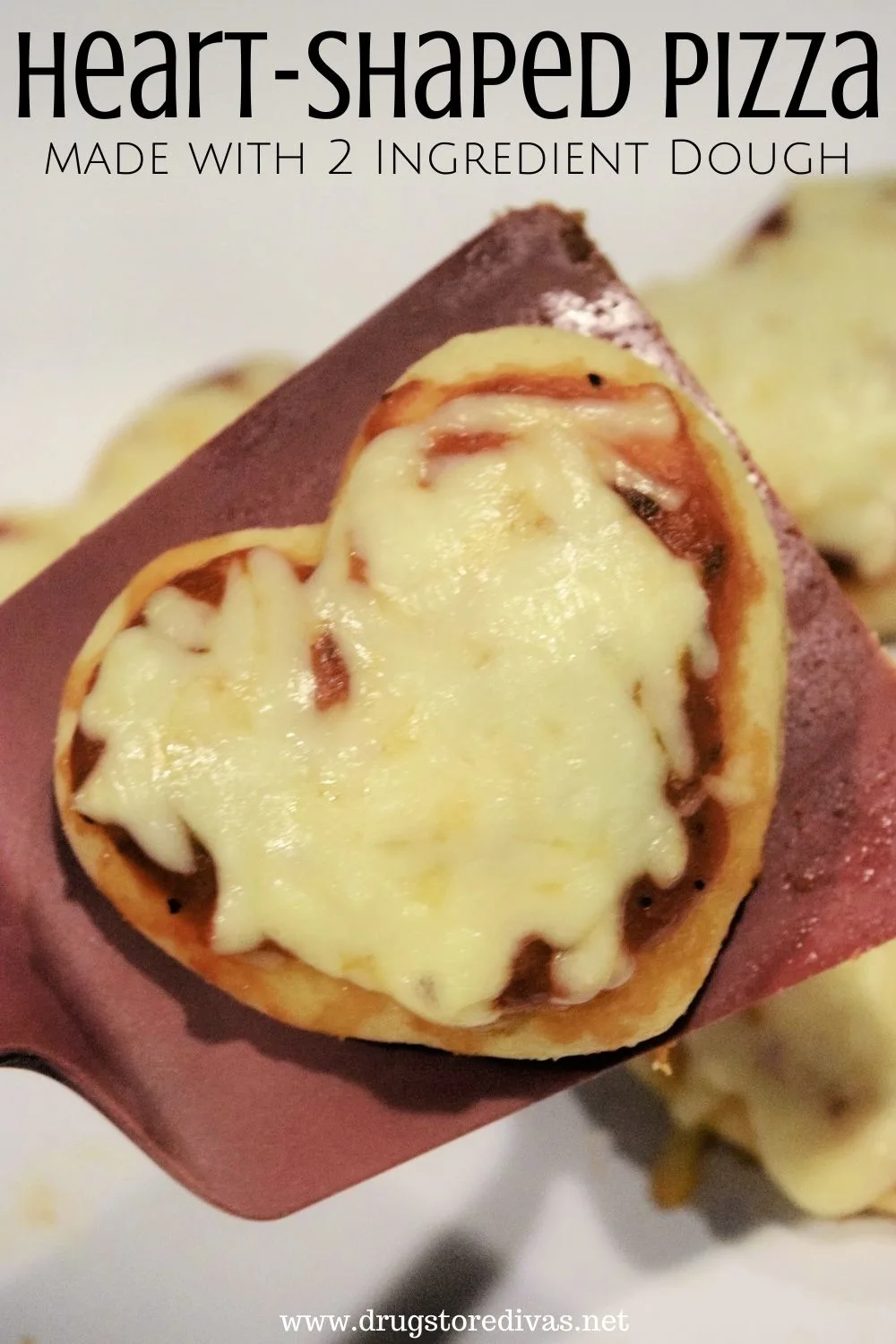 A heart-shaped pizza on a spatula with the words 
