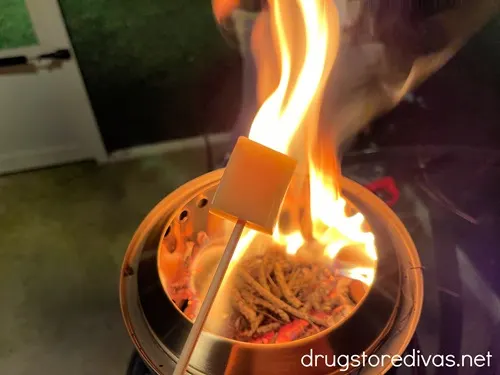 A piece of cheese on a skewer over the flame of a Solo Stove.