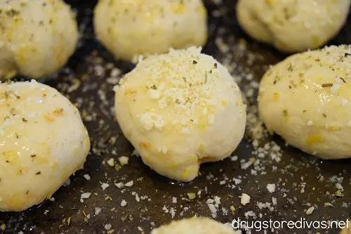 Dough balls with parmesan and cheese on top.