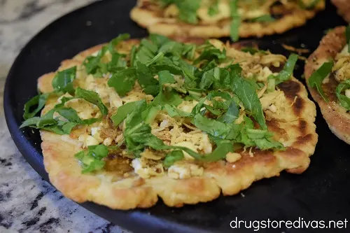 This Shredded Chicken And Arugula Flatbread is easy to make for a decadent feeling weeknight dinner. And it's made from 2 Ingredient Dough.