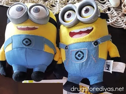 Two Minions stuffed animals laying on a table.