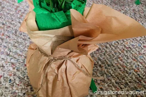 A vase wrapped in tan tissue paper.