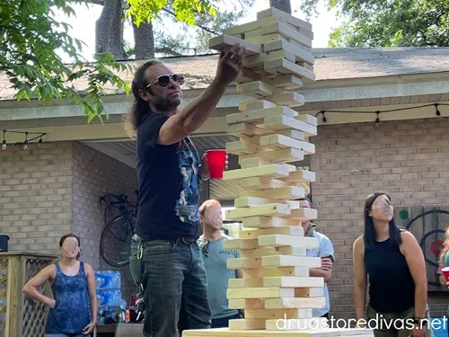 A man playing a giant Jenga game.