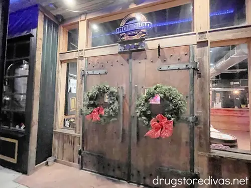 The outside of Ironclad Brewery in WIlmington, NC with two round Christmas wreaths on the doors.