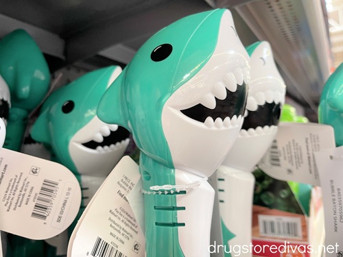 A bunch of teal shark wands on a shelf in a store.