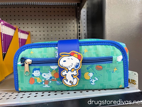 A Snoopy pencil case on a shelf.
