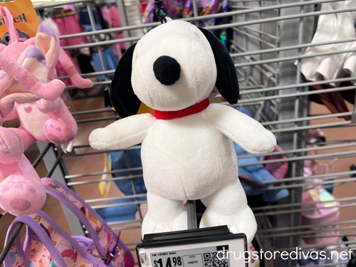 A Snoopy stuffed toy on a peg in a store.