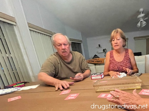 A man and a woman playing a card game at a table.