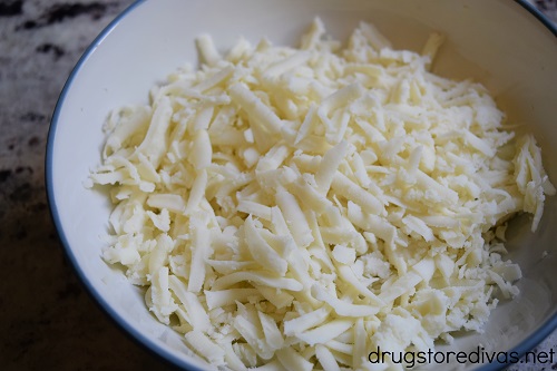 Shredded mozzarella cheese in a bowl.