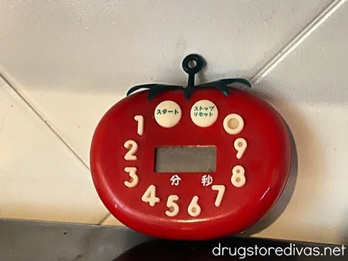 A tomato-shaped kitchen timer in a kitchen.