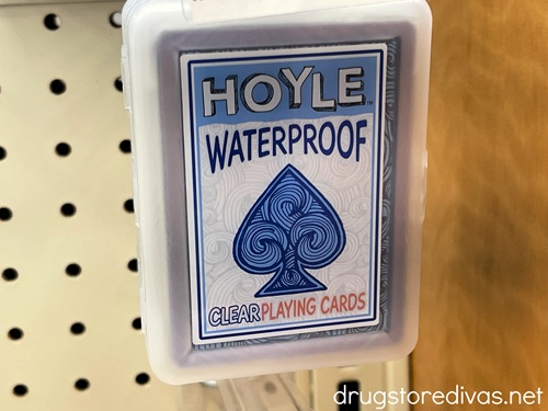A pack of waterproof playing cards hanging on a peg in a store.