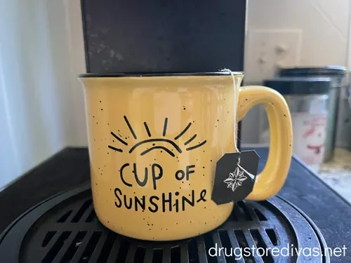 A yellow mug that says Cup of Sunshine on it.