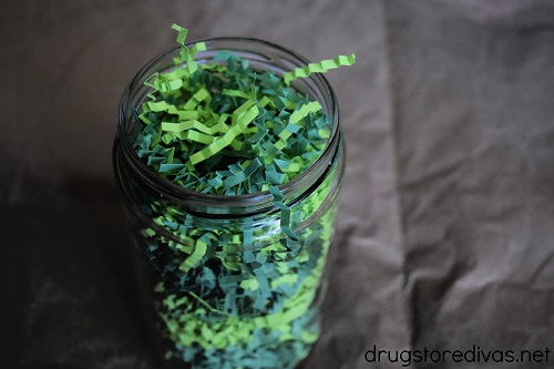 Mason jar filled with green paper shred.