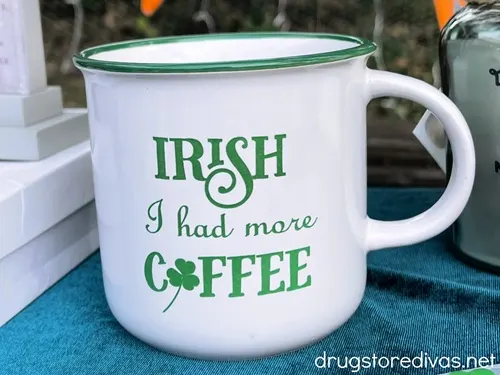 A white mug with green letters that says Irish I had more coffee.
