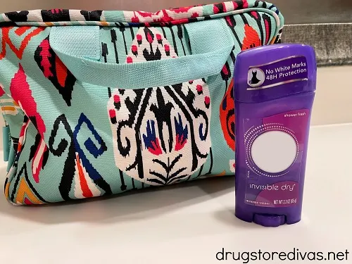 A toiletry bag with a deodorant in front of it.