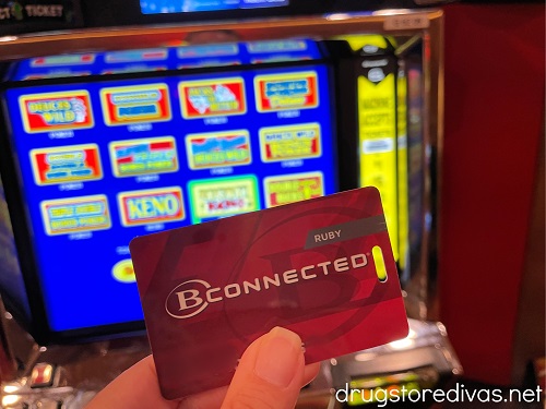 A players card in front of a slot machine.