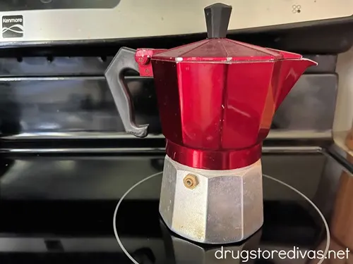 A red and silver percolator on a stove.