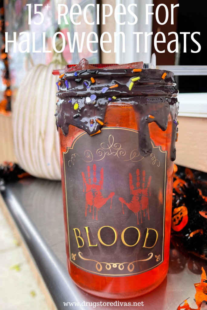 A red drink called blood on a window counter with the words "15+ Recipes For Halloween Treats" digitally written on top.