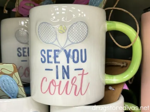 A mug with two tennis racquets on it that says See you In Court on it.