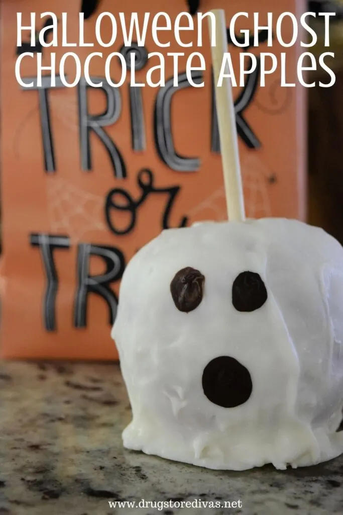 Apple decorated to look like a ghost with a trick or treat bag behind it and the words "Halloween Ghost Chocolate Apples" digitally written on top.