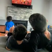 Three boys watching television.