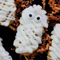 Nutter Butter mummy cookies on orange paper shred with the words 