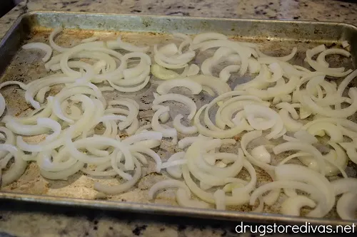 Sliced onions on a sheet pan.