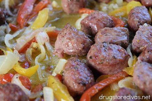 Cooked sausage and peppers on a sheet pan.