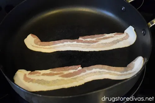 Two pieces of bacon in a pan.