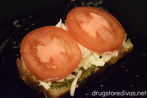 Tomato slices and mozzarella cheese on a slice of bread in a pan.