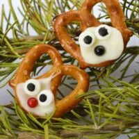 Two homemade reindeer-shaped pretzels on rosemary with the words 